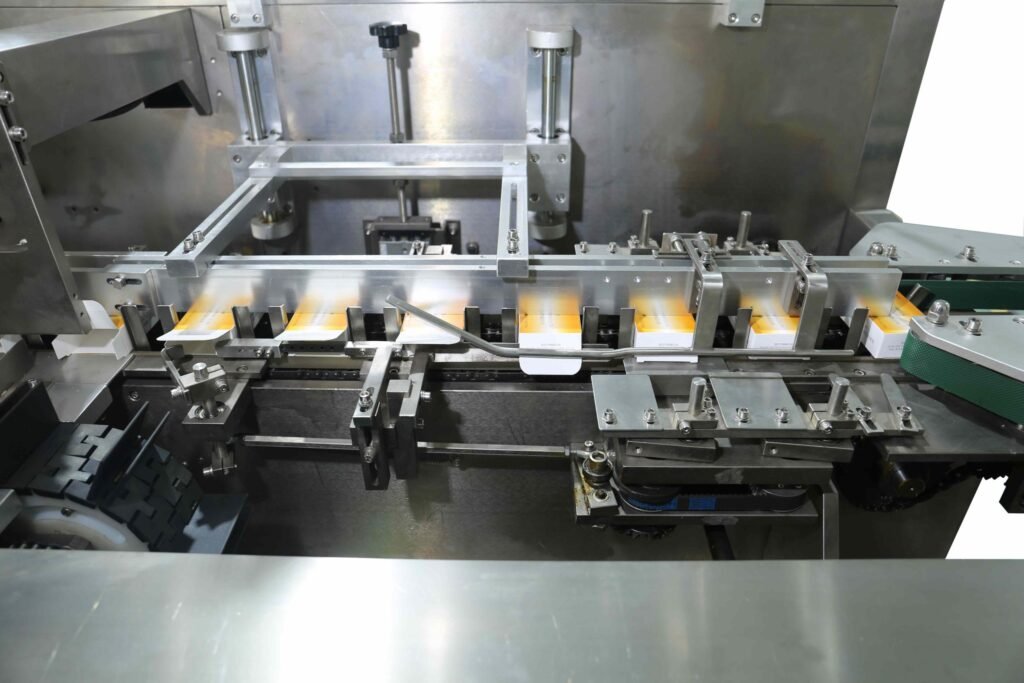 showing carton feeding, product insertion, and box closing process