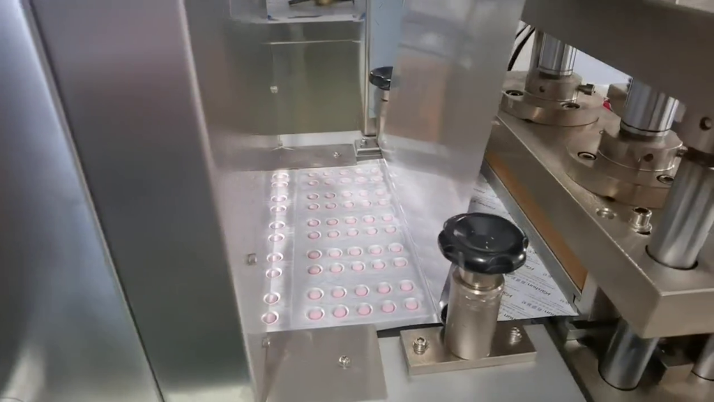 Blister packaging machine forming and sealing tablets in a pharmaceutical production line